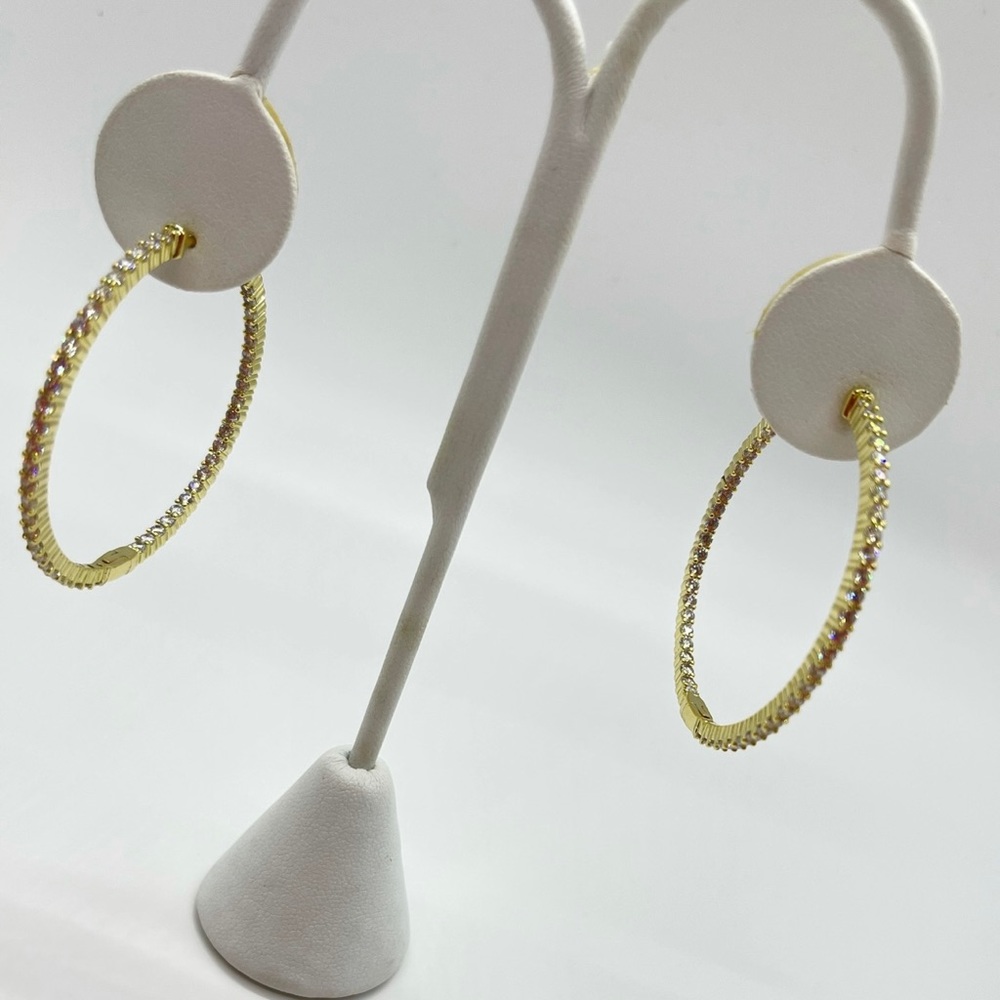 Women’s gold diamond studded hoop earrings.